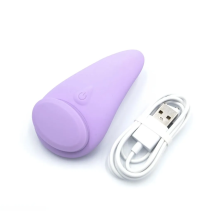 Wibrator z widocznym przyciskiem zasilania oraz dołączonym białym kablem USB do ładowania