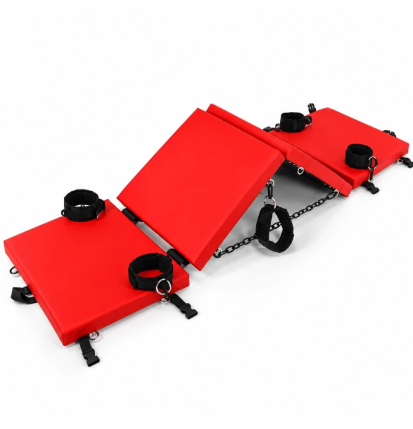 Wielofunkcyjna ławka BDSM Scarlet Flex Bench w rozłożonej konfiguracji z czarnymi kajdankami, opaskami i łańcuchami